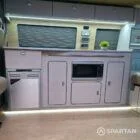 Stylish Spartan SWB conversion interior with two-tone oak kitchen, champagne oak floor, and upholstered seats.