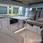 Spartan SWB campervan interior with champagne oak flooring, latte kitchen units, and liquor upholstery seating.
