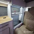 Stylish Spartan SWB conversion interior with two-tone oak kitchen, champagne oak floor, and upholstered seats.