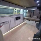 Warm interior design of Spartan SWB campervan with oak flooring, latte cabinets, and premium upholstery.
