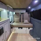 Compact campervan kitchen and seating finished in latte and bardolino oak with champagne oak flooring.