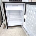 Interior of Spartan Conversion VW T6 featuring winter flooring, latte main units with driftwood detailing, and liquor upholstery seating.