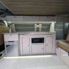 Interior of Spartan Conversion VW T6 featuring winter flooring, latte main units with driftwood detailing, and liquor upholstery seating.
