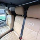 Interior of Spartan Conversion VW T6 featuring winter flooring, latte main units with driftwood detailing, and liquor upholstery seating.