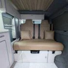 Interior of Spartan Conversion VW T6 featuring winter flooring, latte main units with driftwood detailing, and liquor upholstery seating.