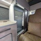 Interior of Spartan Conversion VW T6 featuring winter flooring, latte main units with driftwood detailing, and liquor upholstery seating.