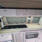 Interior of Spartan Conversion VW T6 featuring winter flooring, latte main units with driftwood detailing, and liquor upholstery seating.