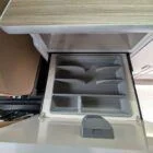 Interior of Spartan Conversion VW T6 featuring winter flooring, latte main units with driftwood detailing, and liquor upholstery seating.