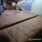 Interior of a Spartan Campers conversion featuring a champagne oak floor, latte and Winchester oak kitchen units, and toffee-coloured upholstery, creating a warm, modern, and cosy living space.