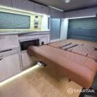 Interior of a Spartan Campers conversion featuring a champagne oak floor, latte and Winchester oak kitchen units, and toffee-coloured upholstery, creating a warm, modern, and cosy living space.
