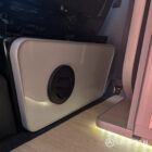 Interior of a Spartan Campers conversion featuring a champagne oak floor, latte and Winchester oak kitchen units, and toffee-coloured upholstery, creating a warm, modern, and cosy living space.