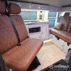 Interior of a Spartan Campers conversion featuring a champagne oak floor, latte and Winchester oak kitchen units, and toffee-coloured upholstery, creating a warm, modern, and cosy living space.