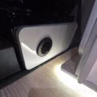 Interior of a Spartan Campers conversion featuring a champagne oak floor, latte and Winchester oak kitchen units, and toffee-coloured upholstery, creating a warm, modern, and cosy living space.