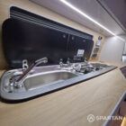 Interior of a Spartan Campers conversion featuring a champagne oak floor, latte and Winchester oak kitchen units, and toffee-coloured upholstery, creating a warm, modern, and cosy living space.