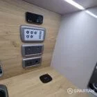 Interior of a Spartan Campers conversion featuring a champagne oak floor, latte and Winchester oak kitchen units, and toffee-coloured upholstery, creating a warm, modern, and cosy living space.