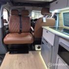 Interior of a Spartan Campers conversion featuring a champagne oak floor, latte and Winchester oak kitchen units, and toffee-coloured upholstery, creating a warm, modern, and cosy living space.