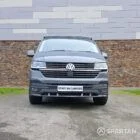 Volkswagen T6.1 long-wheelbase in Pure Grey, fitted with a Spartan camper conversion featuring the slide-and-swivel bench, clean interior lines and subtle exterior styling, parked outdoors.