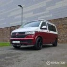 Volkswagen T6.1 short-wheelbase in Candy White and Fortana Red, fitted with a Spartan camper conversion, showing the clean interior layout, modular storage and signature slide-and-swivel bench.