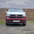 Volkswagen T6.1 short-wheelbase in Candy White and Fortana Red, fitted with a Spartan camper conversion, showing the clean interior layout, modular storage and signature slide-and-swivel bench.