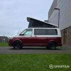 Volkswagen T6.1 short-wheelbase in Candy White and Fortana Red, fitted with a Spartan camper conversion, showing the clean interior layout, modular storage and signature slide-and-swivel bench.