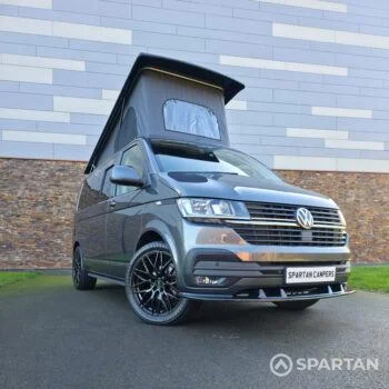 VW T6.1 Transporter in Indium Grey with a Spartan campervan conversion, parked outdoors with clean lines and a practical touring profile.