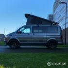 VW T6.1 Transporter in Indium Grey with a Spartan campervan conversion, parked outdoors with clean lines and a practical touring profile.
