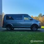 VW T6.1 Transporter in Indium Grey with a Spartan campervan conversion, parked outdoors with clean lines and a practical touring profile.