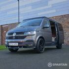 VW T6.1 Transporter in Indium Grey with a Spartan campervan conversion, parked outdoors with clean lines and a practical touring profile.