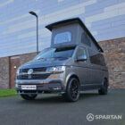 VW T6.1 Transporter in Indium Grey with a Spartan campervan conversion, parked outdoors with clean lines and a practical touring profile.