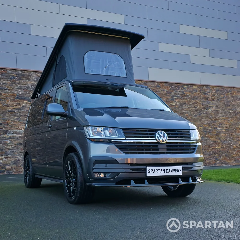 VW T6.1 Transporter in Indium Grey with a Spartan campervan conversion, parked outdoors with clean lines and a practical touring profile.