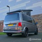 VW T6.1 Transporter in Indium Grey with a Spartan campervan conversion, parked outdoors with clean lines and a practical touring profile.