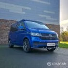 VW T6.1 Transporter in Ravenna Blue, fitted with a Spartan campervan conversion, parked outdoors. Clean lines, factory stance, and upgraded camper profile visible