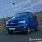VW T6.1 Transporter in Ravenna Blue, fitted with a Spartan campervan conversion, parked outdoors. Clean lines, factory stance, and upgraded camper profile visible