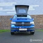 VW T6.1 Transporter in Ravenna Blue, fitted with a Spartan campervan conversion, parked outdoors. Clean lines, factory stance, and upgraded camper profile visible