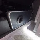 Interior of a Spartan Campers conversion with a Winter floor, indigo blue and taupe kitchen units, and dusk-grey upholstery, giving the space a calm, modern winter palette.