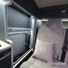 Interior of a Spartan Campers conversion with a Winter floor, indigo blue and taupe kitchen units, and dusk-grey upholstery, giving the space a calm, modern winter palette.