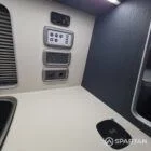 Interior of a Spartan Campers conversion with a Winter floor, indigo blue and taupe kitchen units, and dusk-grey upholstery, giving the space a calm, modern winter palette.