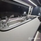 Interior of a Spartan Campers conversion with a Winter floor, indigo blue and taupe kitchen units, and dusk-grey upholstery, giving the space a calm, modern winter palette.