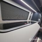 Interior of a Spartan Campers conversion with a Winter floor, indigo blue and taupe kitchen units, and dusk-grey upholstery, giving the space a calm, modern winter palette.