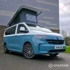VW Transporter T7 campervan, with full Spartan Campers conversion. Front drivers quarter with pop top up and front wheels turned