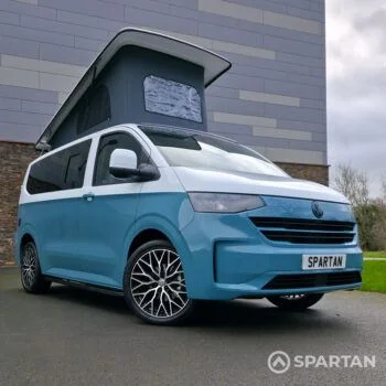 VW Transporter T7 campervan, with full Spartan Campers conversion. Front drivers quarter with pop top up and front wheels turned