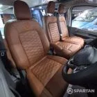 VW T7 Transporter with Spartan campervan conversion with drivers seat and front double bench seat upholstered in fudge from the drivers side