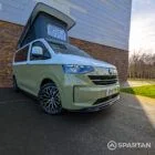 VW Transporter T7 campervan with full Spartan Campers conversion in white and military green, drivers front quarter with the poptop roof up
