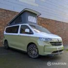VW Transporter T7 campervan with full Spartan Campers conversion in white and military green, drivers front quarter with the poptop roof up