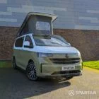 VW Transporter T7 campervan with full Spartan Campers conversion in white and military green, drivers front quarter with the poptop roof up