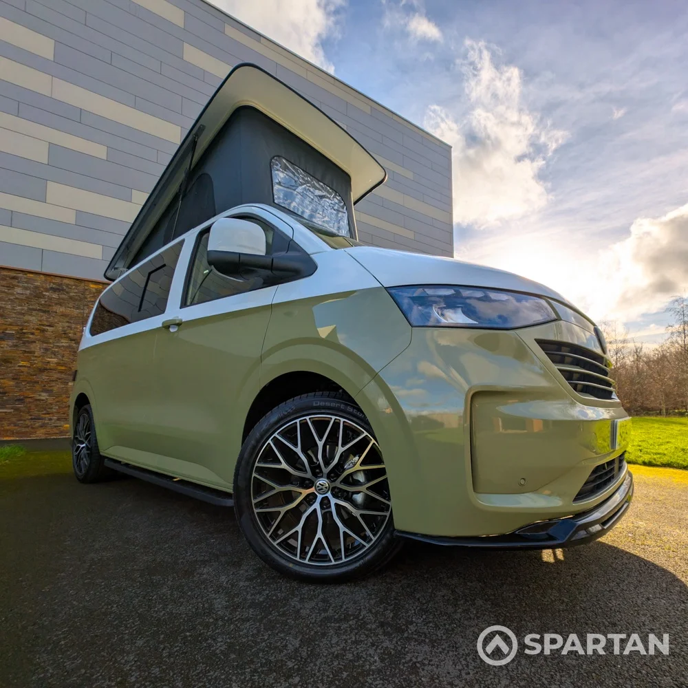 VW Transporter T7 campervan with full Spartan Campers conversion in white and military green, drivers front quarter with the poptop roof up