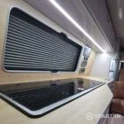 VW T7 Transporter with Spartan campervan conversion interior with latte and amber oak kitchen with twin gas burner and sink lid down and savvy van digital display