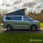 VW Transporter T7 campervan with full Spartan Campers conversion in white and military green, drivers side with the poptop roof up