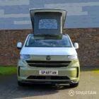 VW Transporter T7 campervan with full Spartan Campers conversion in white and military green, front on with the poptop roof up