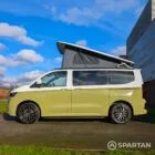 VW Transporter T7 campervan with full Spartan Campers conversion in white and military green, passenger side with the poptop roof up
